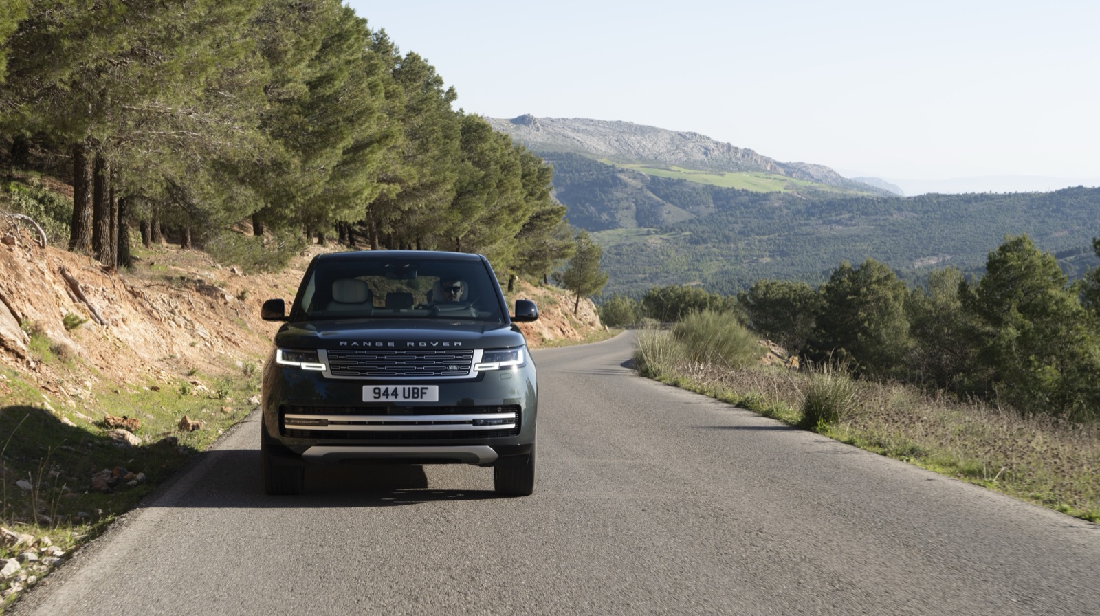 山岳路のワインディングを走行するRANGE ROVER ELECTRICのフロントビュー